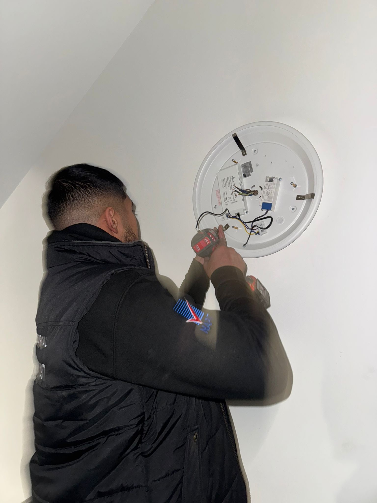 Niaz from MN Electrical installing emergency lighting ceiling fitting — emergency lighting installation service London and Essex